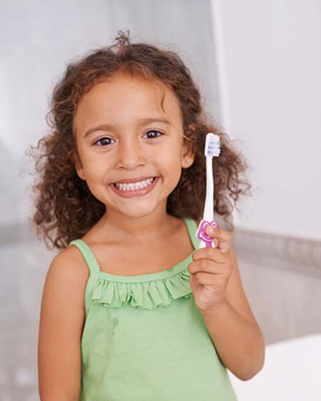 Young girl with toothbrush smiling