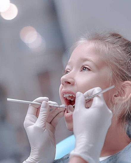 Girl getting teeth examined