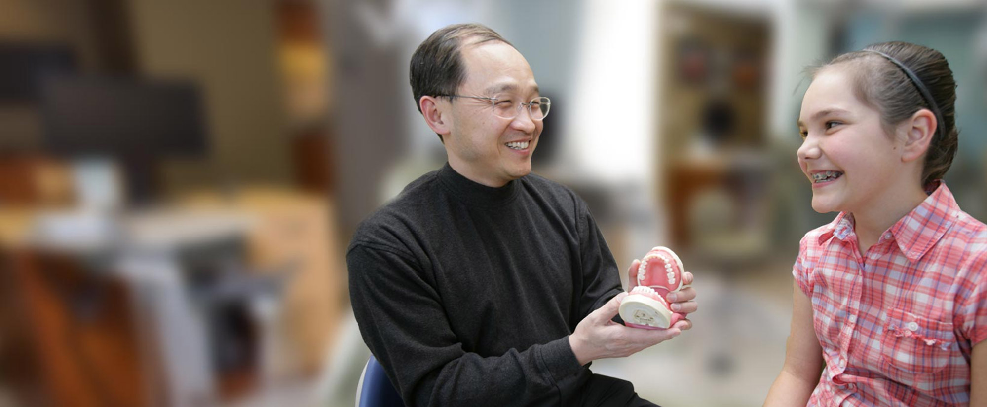 Dr. Tong showing mouth model to patient